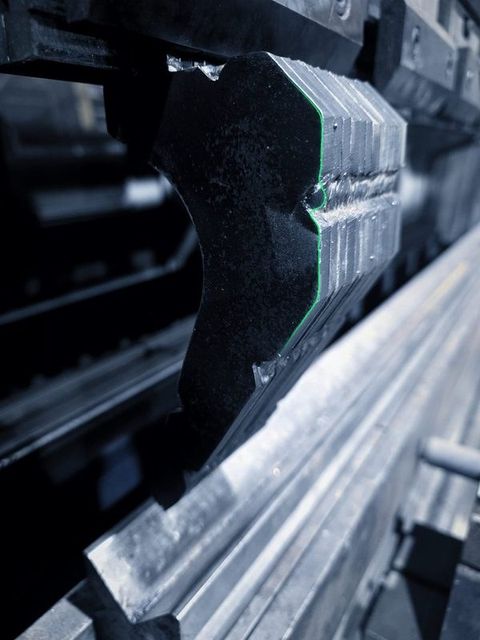 A stack of bent plates held up at the press brake