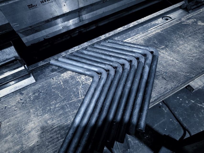 A row of bent rods lined up on the bench