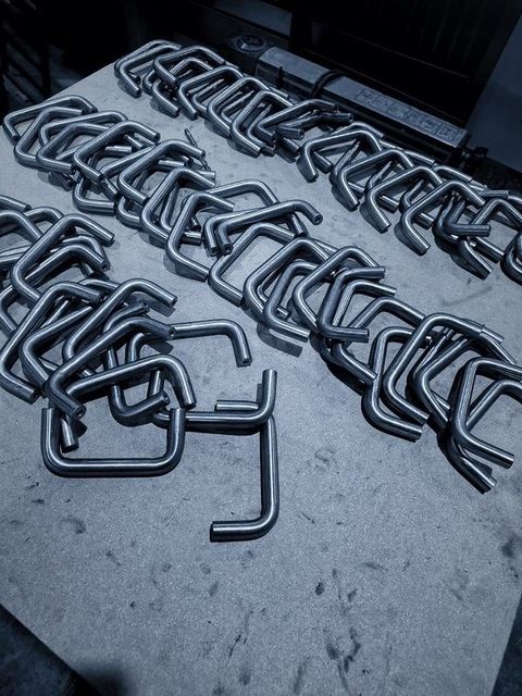 A pile of bent D shaped handles on a table
