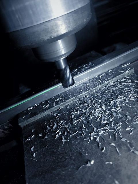 An end mill cuts a slot, with chips piled along the cut