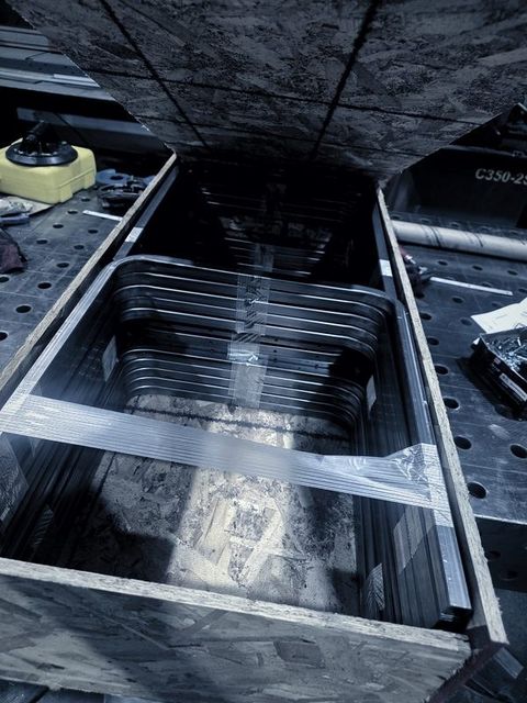 Formed parts wrapped in film inside a wooden crate