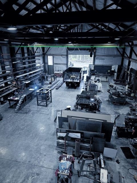 The shop floor seen from above, with a welding arc lit in the middle